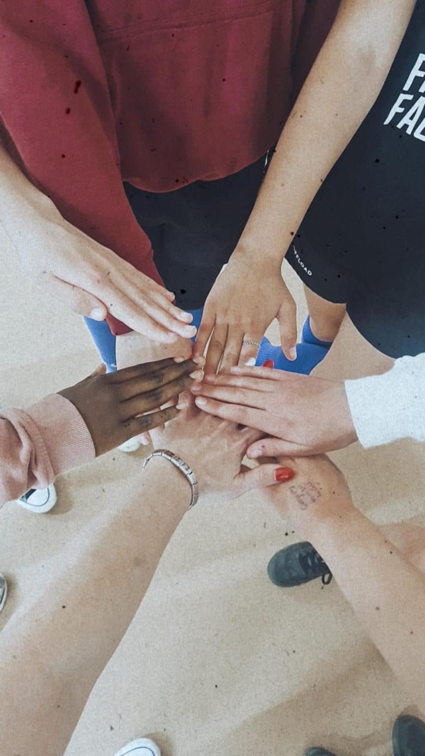 a group of hands coming together in the middle in a circle